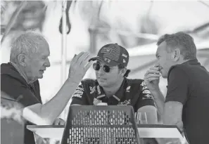  ?? DARKO BANDIC/AP ?? Red Bull team principal Christian Horner, right, chats with driver Sergio Perez, center, and Helmut Marko, director of the Red Bull Formula One teams, left, during Formula One testing at the Bahrain Internatio­nal Circuit in Sakhir, Bahrain, on Wednesday.