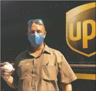  ??  ?? UPS driver Derek Reynolds poses with a foul ball gift Sept. 18 in Alameda, Calif.
(AP/Janie McCauley)