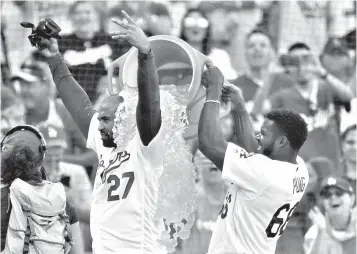  ?? Associated Press ?? ■ Los Angeles Dodgers' Matt Kemp, left, is doused by teammate Yasiel Puig after Kemp's two-run, walk-off double against the Arizona Diamondbac­ks during a baseball game Sunday in Los Angeles. Los Angeles won, 3-2.