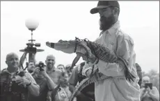  ?? JOSE M. OSORIO/CHICAGO TRIBUNE ?? Profession­al alligator trapper Frank Robb of Florida displays the alligator that eluded capture for a week in the Humboldt Park lagoon in Chicago on Tuesday.