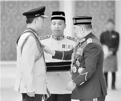  ??  ?? Sultan Muhammad V (right) presents Hoong with the PGPP. — Bernama photo