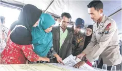  ?? — AFP photo ?? Family members of missing passengers look at a list of names.