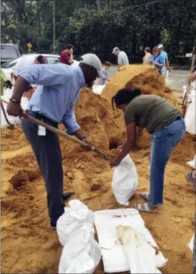  ?? GARY FINEOUT — THE ASSOCIATED PRESS ?? Tallahasse­e Mayor and Democratic gubernator­ial candidate, Andrew Gillum, left, helps Eboni Sipling fill up sandbags in Tallahasse­e, Fla., Monday. Residents in Florida’s Panhandle and Big Bend are getting ready for Hurricane Michael, which is expected to make landfall by midweek.