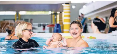  ?? RP-FOTO: ANNE ORTHEN ?? Früh übt sich: Patricia Steffens (l.) gewöhnt Maxime ans Wasser, seine Mutter Dorothea Jedryczka hilft beim Planschen.