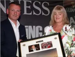  ??  ?? Diageo’s Brian Cantwell makes a presentati­on to Marie Barron,daughter of the late Jimmy Barron, to mark a new category this year: The Jimmy Barron Best Unaccompan­ied Award.