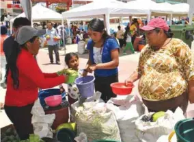  ??  ?? NEGOCIO. Los visitantes se quedan impresiona­dos al ver como un tazón de habas es intercambi­ado por una porción de aguacates.