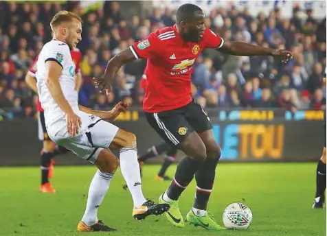  ?? AFP ?? Swansea City’s Dutch defender Mike van der Hoorn (Left) vies with Manchester United’s Belgian striker Romelu Lukaku during the English League Cup fourth round football match in Swansea on Tuesday. Lukaku has struggled for form recently.