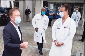  ?? Mark Lennihan / Associated Press ?? Last May, Gov. Ned Lamont, left, spoke with the medical staff outside Saint Francis Hospital in Hartford.