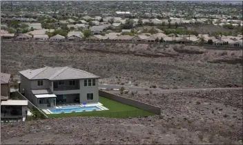  ?? JOHN LOCHER — THE ASSOCIATED PRESS ?? A home with a swimming pool abuts the desert on the edge of the Las Vegas valley, Wednesday in Henderson, Nev. Las Vegas area water officials want to cap the size of new swimming pools, citing worries about supplies from the drying-up Lake Mead reservoir on