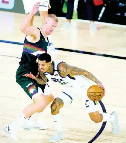  ?? AP ?? Utah Jazz’s Jordan Clarkson (right) drives against Denver Nuggets’ Mason Plumlee during the first half of an NBA basketball first round playoff game yesterday in Lake Buena Vista, Florida. Denver won 135-125 after overtime.