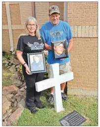  ?? STACI VANDAGRIFF/THREE RIVERS EDITION ?? Tonya and Harold McGary of Searcy hold photos of their son, Will, at a memorial site at their church, Valley Baptist Church in Searcy. Will, who was a Conway police officer, was directing traffic after a vehicle accident Jan. 31, 2013, when an impaired driver hit him. Will, 26, died the next day. His family and friends started the Officer Will McGary Memorial Foundation, which supports youth and police officers, focusing on Searcy and Conway.