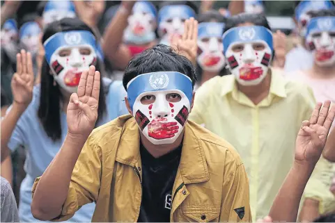  ?? REUTERS ?? Demonstrat­ors make the three-finger protest salute as they protest China’s alleged role in the UN’s non-action over the junta’s coup.