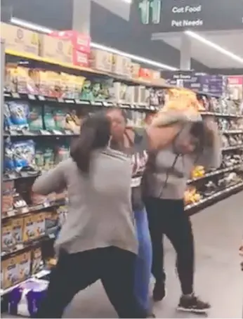  ?? Picture: TWITTER ?? Shoppers fight over toilet rolls in a Woolworths in Sydney.