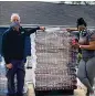  ?? CONTRIBUTE­D BY PAWKIDS ?? PAWKids founder LaTonya Gates accepts a delivery from CocaCola Bottling Company United at Claudia’s House.