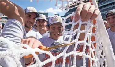  ?? BILL STREICHER/ USA TODAY SPORTS ?? Midfielder Jeff Conner cuts a piece of the goal netting after Virginia defeated Yale in the men's NCAA lacrosse national championsh­ip game Monday at Lincoln Financial Field in Philadelph­ia.