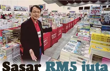  ??  ?? KEE menunjukka­n pelbagai jenis buku yang terdapat di MPH Bookervill­e Carnival Sale di Pusat Konvensyen Setia City, Shah Alam.