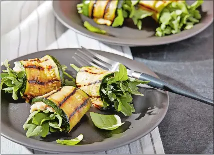  ?? TOM MCCORKLE /THE WASHINGTON POST ?? Grilled zucchini roll-ups with white beans and arugula.