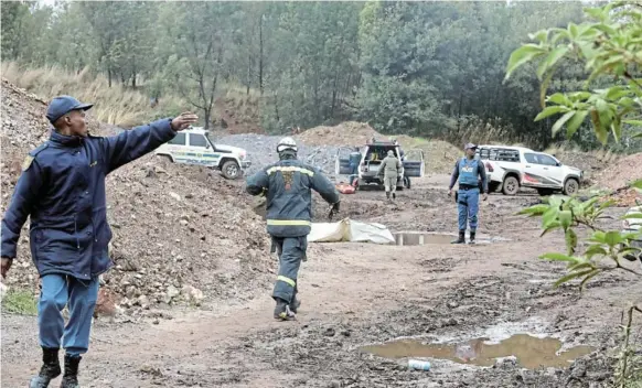  ?? /ANTONIO MUCHAVE ?? A mine rescue team and cops at Shaft 9, where 21 bodies of zama zamas were found in Krugersdor­p on the West Rand.