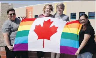  ?? IAN KUCERAK ?? From left, Jennifer Jones, Kennedy Harper, Christina Crowell and Amanda Paulino, members of the Blessed Oscar Romero High School’s Rainbow Ravens gay straight alliance, display a Pride flag.