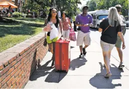  ?? JACQUELYN MARTIN THE ASSOCIATED PRESS ?? Malia Valentine, 18, of Yorktown, Va., left, moves her things into her new dormitory at the University of Virginia with her mother, Michelle Valentine, and father, Carl Valentine, on Friday in Charlottes­ville, Va., a week after a white nationalis­t...