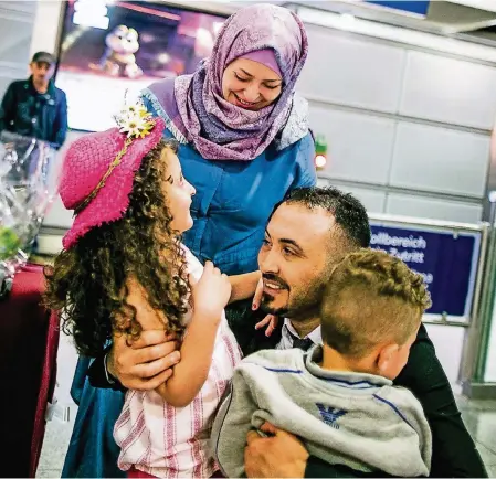  ?? FOTOS: ANNE ORTHEN ?? Esmail Manla Ali (34) empfängt am Düsseldorf­er Flughafen seine Kinder Farah (6) und Ahmed (3) sowie Ehefrau Safaa Mahmoud (30).