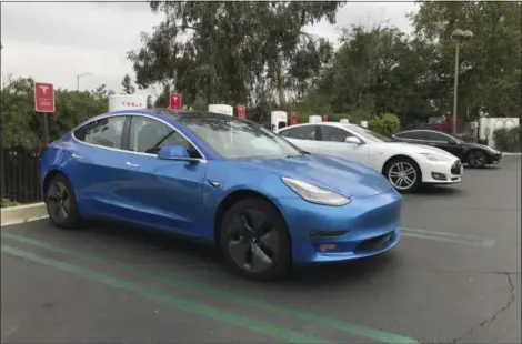  ?? RONALD MONTOYA/EDMUNDS VIA THE ASSOCIATED PRESS ?? This undated photo provided by Edmunds shows a 2017 Tesla Model 3 at one of the many supercharg­er stations across the country.