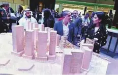  ?? Abdul Rahman/Gulf News ?? Visitors look at a model of ‘Makers District’ project in Reem Island on the first day of Cityscape Abu Dhabi yesterday.