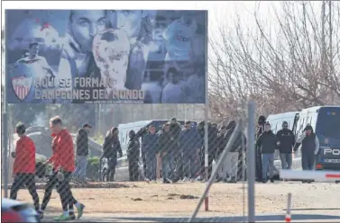  ??  ?? ESCOLTADOS. Los ultras del Sevilla son vigilados por la Policía en la Ciudad Deportiva del Sevilla.