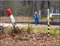  ?? Arkansas Democrat-Gazette/STEPHEN B. THORNTON ?? Markers indicate the location of the Pegasus pipeline in Mayflower as a worker in protective gear walks it March 29 near the spot where the decades-old pipeline ruptured.