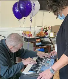  ?? ?? Cara Brooks, right, a volunteer with the Westmorela­nd County chapter of the national nonprofit Twilight Wish Foundation, helps Phillip Horrell set up his new electric keyboard.