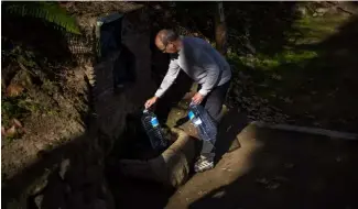  ?? ?? Joan Torrent, 64, fills plastic jugs at a natural spring in Gualba, about 50 km northwest of Barcelona, Spain in January when the drought was at its worst