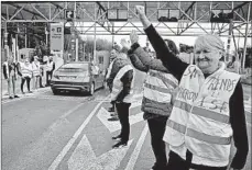  ?? BOB EDME/AP ?? A demonstrat­or wearing a yellow vest reading “Macron give us the wealth tax” protests Wednesday at the toll gates on a motorway in southweste­rn France.