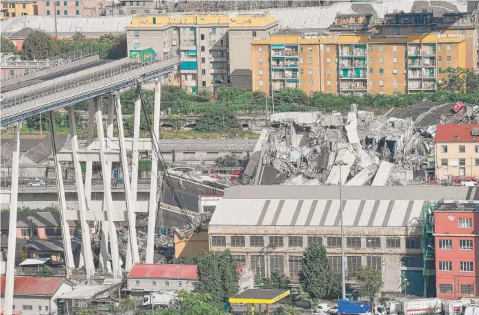  ?? LUCA ZENNARO/ANSA VIA AP ?? A truck is stopped just in front of the portion of a 51-year-old highway bridge that collapsed over an industrial area in the Italian city of Genoa during a sudden storm, leaving vehicles crushed below.