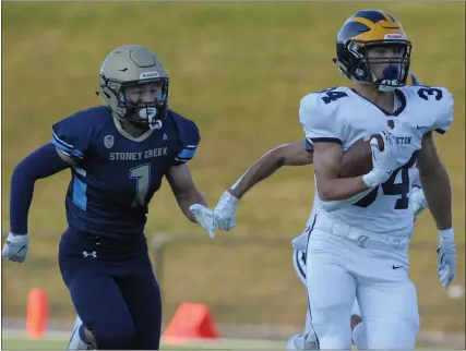  ?? PHOTOS BY KEN SWART — FOR MEDIANEWS GROUP ?? Clarkston’s Ethan Clark (34) outruns Stoney Creek’s Steven Lambert (1) for a 70-yard first-quarter TD. Clark had three touchdowns and 245yards to help lead the Wolves to a 34-13win. The OAA Red game was played on Friday at Stoney Creek High School.