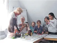  ?? FOTO: RAPP-NEUMANN ?? Sieben Mädchen haben mit Museumspäd­agogin Sigrid Radler in Ellwangen alamannisc­he Blütendüft­e hergestell­t.