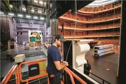  ?? WILLIE J. ALLEN JR./ORLANDO SENTINEL ?? Danny Maldonado, a rigger for the Internatio­nal Alliance of Theatrical Stage Employees union, steadies a column from atop the scissor lift as the crew builds the set for the 2023 Orlando Ballet’s “The Nutcracker” on Sunday inside Steinmetz Hall in Orlando.
