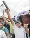  ??  ?? Protesta. Un mortero casero porta un hombre durante un funeral.