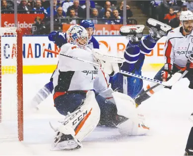  ?? JOHN E. SOKOLOWSKI/USA TODAY SPORTS ?? Toronto Maple Leafs forward Mitchell Marner takes a spill in front of Washington Capitals goaltender Braden Holtby, early in Tuesday’s action at Scotiabank Arena in Toronto. The Capitals emerged 4-3 winners in OT.