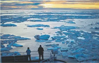  ?? David Goldman, The Associated Press ?? Researcher­s look out from the Finnish icebreaker MSV Nordica as the sun sets over sea ice in the Victoria Strait along the Northwest Passage in the Canadian Arctic Archipelag­o. Global warming fears have grown over the last 30 years.