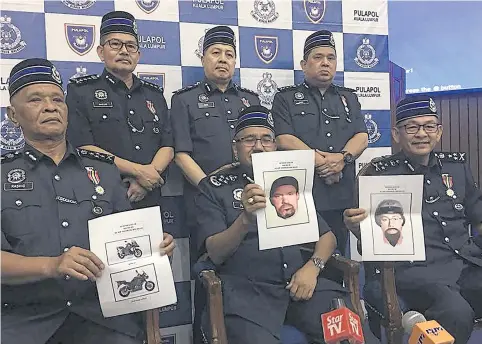  ?? AFP ?? Malaysia’s chief of police Mohamad Fuzi Harun, centre, stands with other officers holding images of suspects involved in the assassinat­ion of a Palestinia­n scientist.