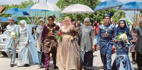  ??  ?? TIGA pasangan dari kiri, Muhamad Arif, Nor Shafina; Muhammad Razin, Nur Hidayah Ismail; Muhammad Fitri dan Siti Shahirah berarak pada perkahwina­n mereka di Kampung Aman, Kepala Batas.