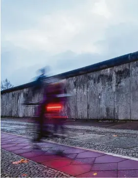  ?? ?? Ein Radfahrer fährt an der Gedenkstät­te in der Bernauer Straße vorbei. Rund 140 Menschen verloren zwischen 1961 und 1989 an der Berliner Mauer ihr Leben.