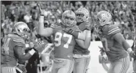  ?? AP/MICHAEL CONROY ?? Ohio State defensive lineman Joey Bosa (97) is greeted by teammates after returning a fumble for a touchdown against Wisconsin during the Big Ten Championsh­ip Game.