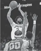  ?? RICK SCUTERI/AP ?? Lakers forward Anthony Davis shoots over Suns center Javale Mcgee (00) and forward Mikal Bridges on Tuesday in Phoenix.