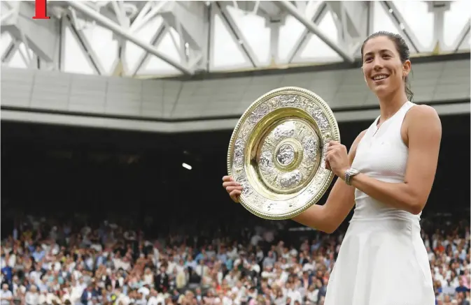  ??  ?? LONDON: Spain’s Garbine Muguruza holds up The Venus Rosewater Dish as she celebrates beating US player Venus Williams to win the women’s singles final on the twelfth day of the 2017 Wimbledon Championsh­ips at The All England Lawn Tennis Club in...