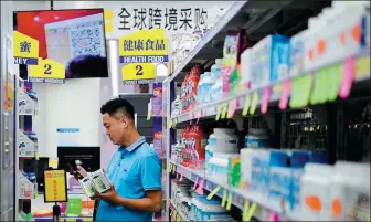  ?? ZHANG HAORAN / XINHUA ?? A visitor buys goods at a cross-border e-commerce expo in Zhengzhou, Henan province.