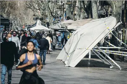  ??  ?? La restauraci­ón Ayer permanecía­n tiradas las sombrillas de uno de los bares atacados en la Rambla, cerca de la comisaría junto a la que fue quemado un furgón policial. El Gremi de Restauraci­ó también denunció los ataques