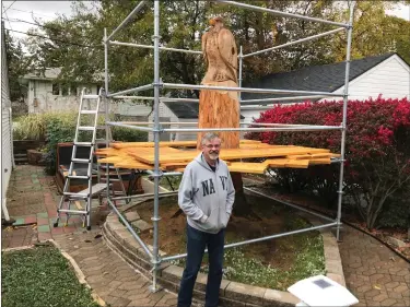  ?? PHOTOS BY JOHN BUTLER — THE NEWS-HERALD ?? The 10-foot-tall eagle statue carved by Carvings by Chris and located at the Kodrin brothers garden at 1744East 230th Street in Euclid. Sly Kodrin stands in the photo, giving proportion to the large carving.