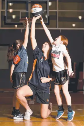  ?? Picture: ALIX SWEENEY ?? NEXT GENERATION: Darcee Garbin with Harper Kyle, 9, and Keely Andrews, 9, during the Townsville Fire’s school holiday clinic at Townsville Stadium.