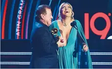  ??  ?? La colombiana Karol G subió al escenario con su padre a recibir el reconocimi­ento.